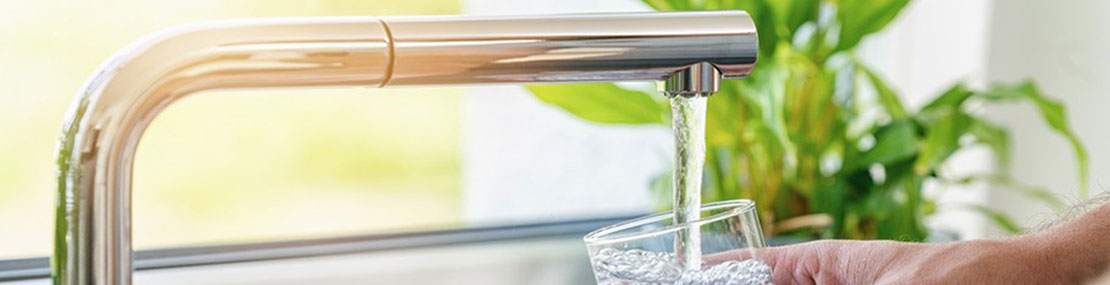 pouring a glass with drinking water from the tap